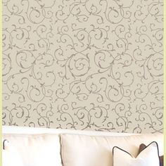 a white couch sitting in front of a wall with decorative designs on it's walls