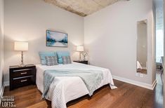 a bedroom with white walls and wood floors