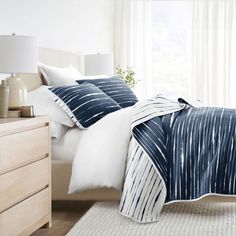 a bed with blue and white comforters in a bedroom