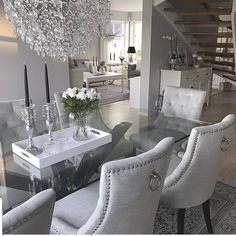 a dining room table with chairs and a chandelier hanging from the ceiling