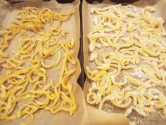 two trays filled with uncooked pasta sitting next to each other