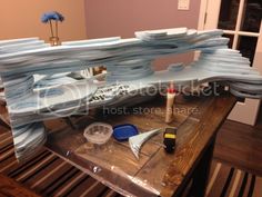 there is a model of a boat on top of a table with paint and glue