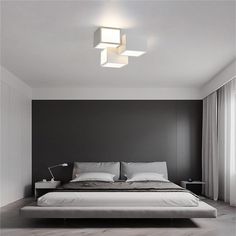 a bedroom with a large bed and two lights on the ceiling