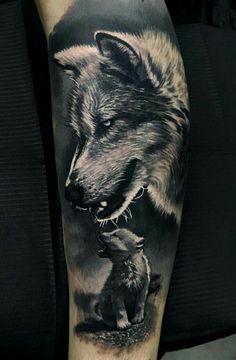 a black and white tattoo of a wolf with a baby animal in its mouth, on the leg