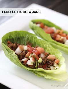 two lettuce cups filled with meat and veggies on a white plate