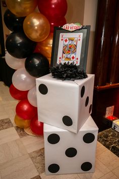 two dices stacked on top of each other in front of balloons