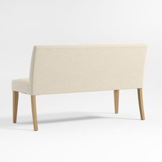 an upholstered white bench with wooden legs