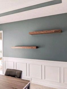 an empty dining room with blue walls and white wainscothes on the wall