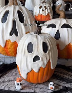 three pumpkins decorated to look like ghost faces