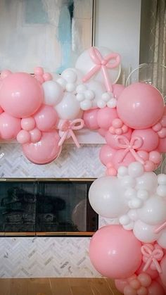 balloons are arranged in the shape of an arch with bows and ribbons on it, along with other decorations