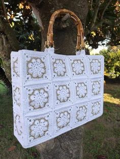 a white crocheted bag hanging from a tree