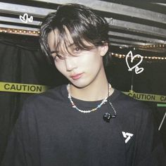 a young man wearing a black shirt and necklace