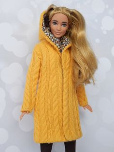 a doll with blonde hair wearing a yellow coat and black leggings, standing in front of a white background