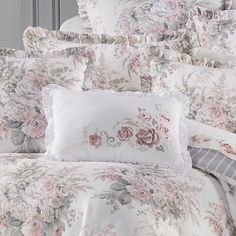 the comforter is made up with pink flowers and ruffled trims on it