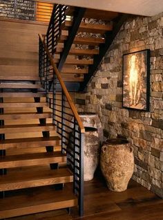 there is a vase next to the stairs in this house with stone walls and wood railings