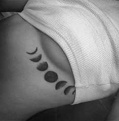 a woman's stomach with three phases of the moon tattooed on her left side