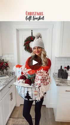 a woman is holding a basket full of gifts in her kitchen with the words christmas gift basket on it