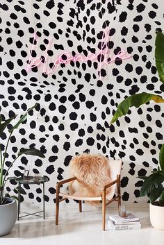 a leopard print wallpaper in a living room with a chair and potted plants