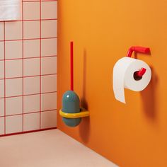 a toilet paper dispenser on the wall next to a roll of toilet paper