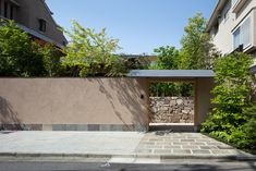 an entrance to a house with stone walls and trees in the back ground, surrounded by greenery