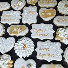 many decorated cookies with gold and white frosting