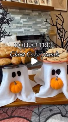 two ghost cake stands with pumpkins and cookies on them in front of a fireplace