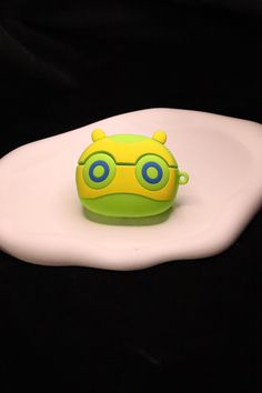 a yellow and green toy sitting on top of a white plate