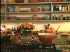 a kitchen filled with lots of plates and bowls on top of a counter next to a stove