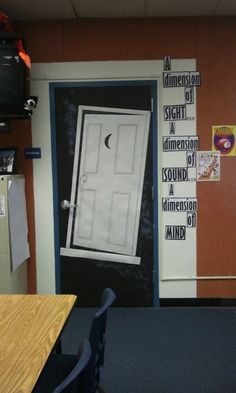 an open door to a classroom with posters on the wall and desks in front of it