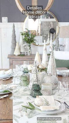 a dining room table set for christmas with white and green decorations on the table top