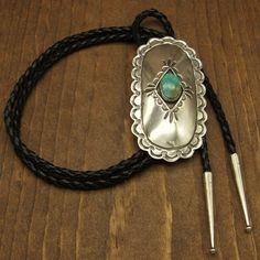 "Large 3 3/4\" tall x 2\" wide bolo tie. Sterling silver shadow box concho style with 3/4\" tall turquoise stone. The center is domed. The edge is scalloped and has nice stamp work. The leather cord and silver tips are 42\" long. The back is stamped sterling. The bolo is in good condition. Thanks for your interest. Please let us know if you have questions. k BOLO-260" Turquoise Bolo Tie, Silver Tips, Bolo Ties, Southwest Jewelry, Turquoise Bracelet Cuff, Sterling Silver Brooch, Bolo Tie, Turquoise Cuff, Silver Brooch