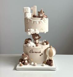 a three tiered cake with teddy bears on top