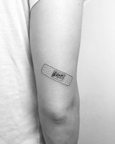 a black and white photo of a person's arm with a tattoo on it