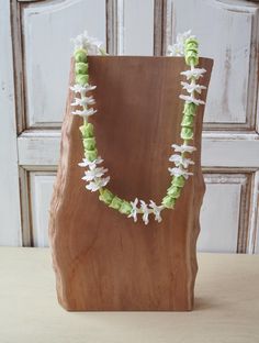 a wooden block with white and green flowers on it