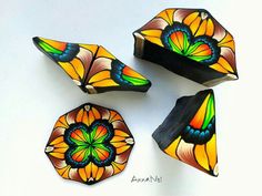 four colorful stained glass pieces sitting on top of a white table next to each other