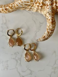 Natural sunstone drops surrounded by brilliant golden brass, add a modern edge to a classic stone. Gemstones are attached to long-lasting 18K gold-plate huggie hoops. All my jewellery is handcrafted by myself in the UK.  I take care with all my pieces, as it feels like a little bit of me goes into each piece.  Items will be sent in a soft velvet bag to keep your jewellery in, ready to be gifted or kept for yourself.  A care guide will be provided for those purchasing gold-plated jewellery.  Care Earrings Gold Hoops, Sunstone Jewelry, Gemstone Drop Earrings, Drop Earrings Gold, Jewelry Safe, Gold Pearl Earrings, Pearl Hoop Earrings, Pearl Earrings Dangle, Jewelry Gemstone