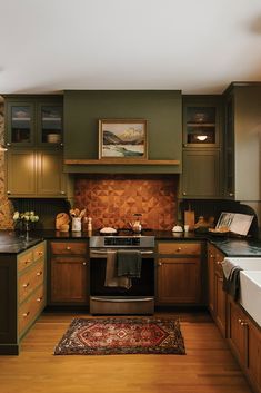 a kitchen with wooden floors and green cabinets, an area rug in front of the stove