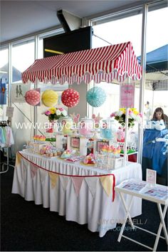 an outdoor candy stand with umbrellas and decorations