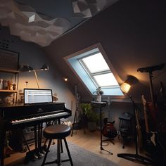 a room with a piano, stool and other musical instruments on the floor in front of an open window