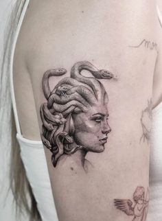 a woman's head with snakes on her shoulder