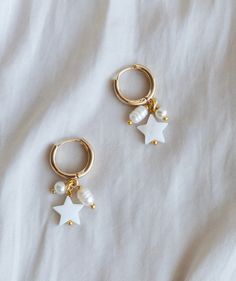 These playful gold hoops feature a Mother-of-Pearl star, and small glass pearl, and an elongated freshwater pearl. The hoops fasten themselves so there is no need for a backing! This little cluster of fun is sure to bring a smile to your face or the person you gift it to! I put a lot of love and thought into every piece I make :) Your product may vary slightly from the photos due to natural variations in the pearls or other handmade aspects of the item, but rest assured that you will be getting Heart Bubbles, Multiple Earrings, Star Struck, Earrings Star, Hoops Gold, Mother Of Pearl Earrings, Dangle Charms, Gold Hoops, Jewelry Earrings Hoops