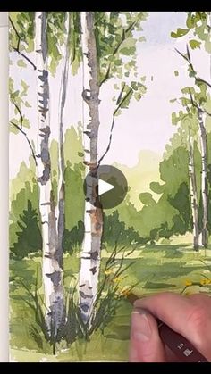 someone is painting trees with watercolors on paper