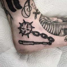 a man's foot with a tattoo on it and a chain attached to the ankle