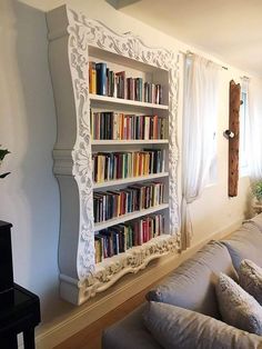 a living room filled with furniture and a bookshelf next to a wall mounted book shelf