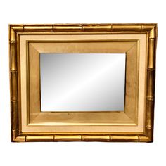 a gold framed mirror sitting on top of a white wall