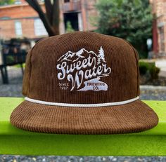 Wanna rep your favorite craft brewery in style? Look no further! This hat will keep the sun out of your eyes, and everyone else's eyes on you! Details: Shape: Flatbill Fabric: 100% Polyester Adjustable Snapback: One Size Fits Most Camp Merch, Graphic Hats, Mens Hats, Craft Brewery, Bar Accessories, Your Eyes, Cowboy Boots, Hats For Men, In Style