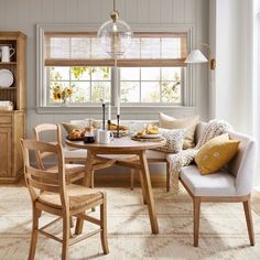 a dining room table and chairs in front of a window