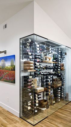 a wine cellar in the corner of a room with wooden flooring and white walls