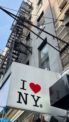 i love new york sign hanging on the side of a building in manhattan, new york