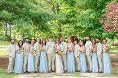 a group of people standing next to each other in front of trees